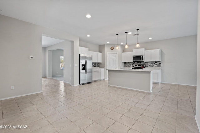 kitchen featuring stainless steel appliances, white cabinets, light tile patterned flooring, hanging light fixtures, and a center island with sink