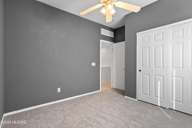 unfurnished bedroom featuring ceiling fan, a closet, and light carpet