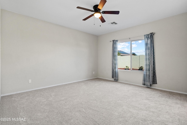 empty room featuring ceiling fan and carpet