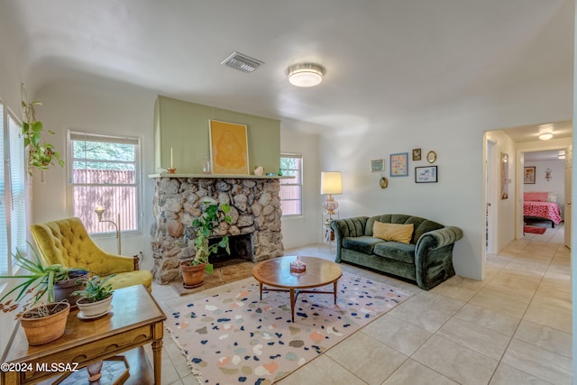 living room with light tile patterned floors and a fireplace