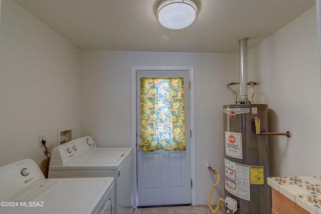 laundry room featuring light tile patterned flooring, separate washer and dryer, and water heater