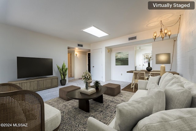 carpeted living room featuring a chandelier