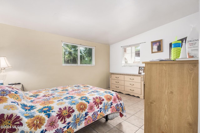 bedroom featuring lofted ceiling, tile patterned floors, and multiple windows