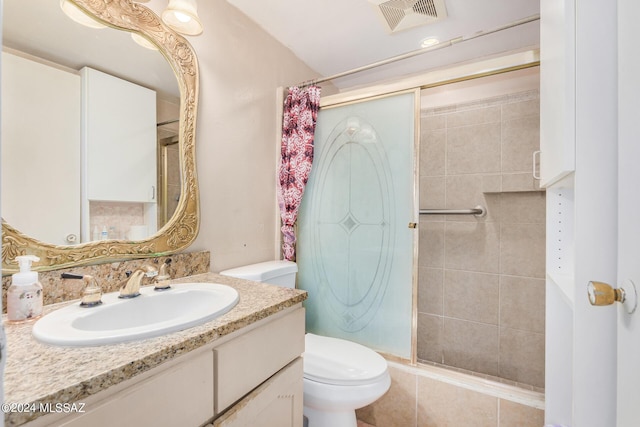 bathroom featuring vanity, tiled shower, and toilet