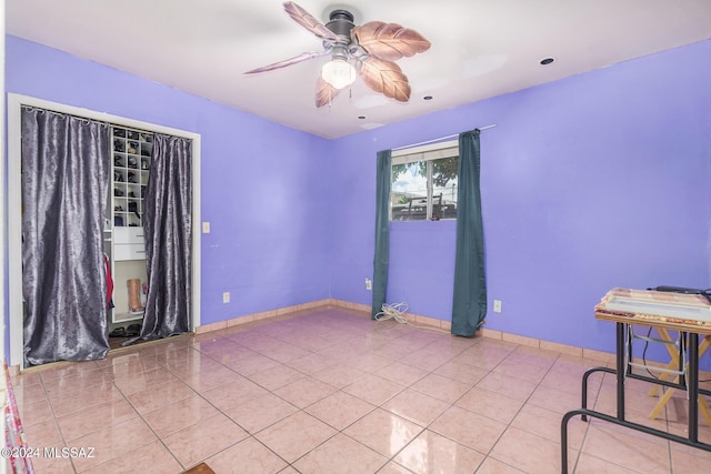 tiled empty room featuring ceiling fan