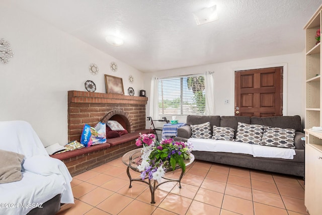 living room featuring a fireplace, a textured ceiling, and light tile patterned floors