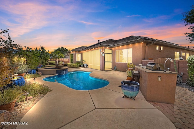 pool at dusk featuring an in ground hot tub and a patio area