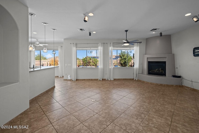 unfurnished living room featuring a fireplace, light tile patterned floors, and ceiling fan