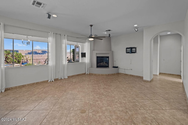 unfurnished living room with light tile patterned flooring, ceiling fan, and a large fireplace