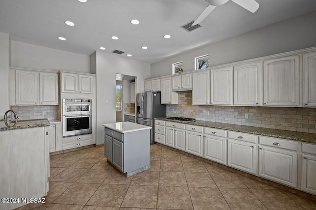 kitchen featuring appliances with stainless steel finishes, decorative backsplash, and a kitchen island