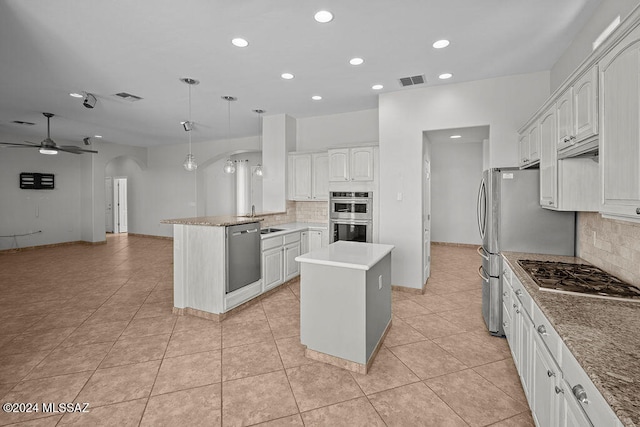 kitchen with white cabinets, hanging light fixtures, kitchen peninsula, stainless steel appliances, and a center island