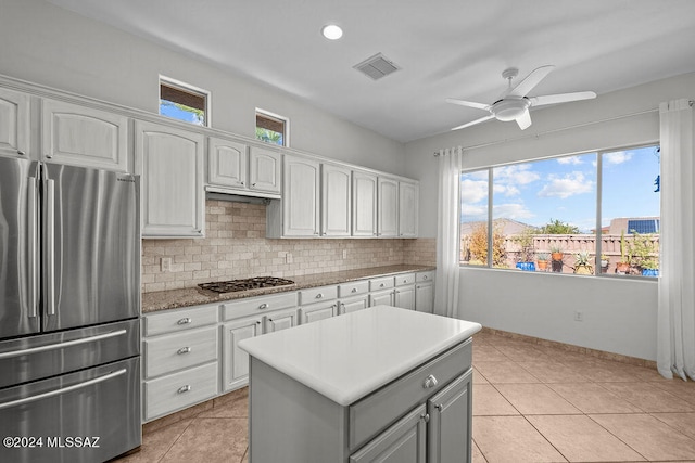 kitchen featuring appliances with stainless steel finishes, ceiling fan, decorative backsplash, and white cabinets