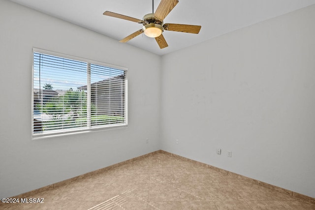 tiled spare room with ceiling fan