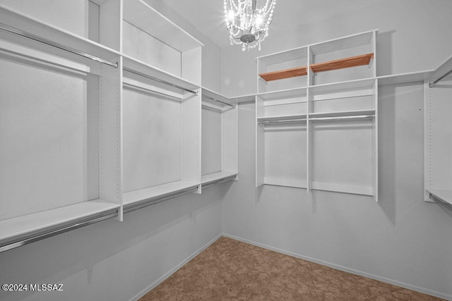 spacious closet with a notable chandelier and carpet