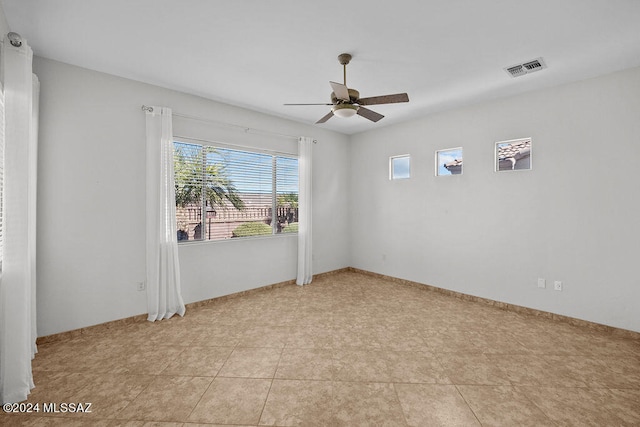 tiled spare room featuring ceiling fan