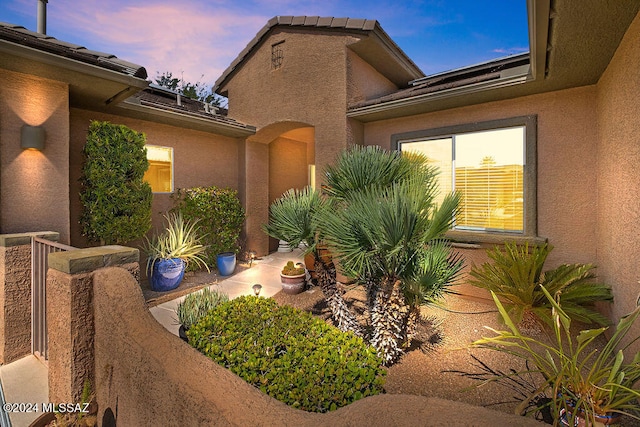 property exterior at dusk featuring a patio area