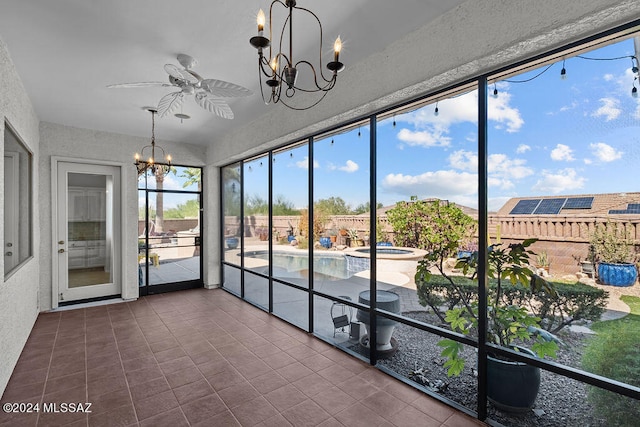 unfurnished sunroom featuring ceiling fan with notable chandelier