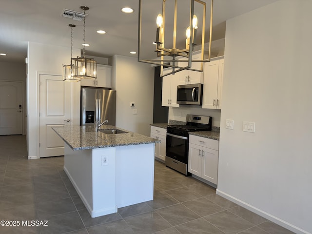kitchen featuring dark tile patterned floors, a chandelier, appliances with stainless steel finishes, and a sink
