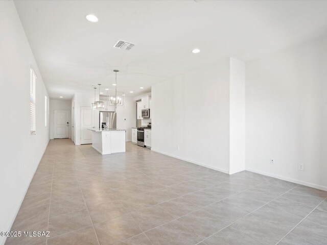 unfurnished living room featuring recessed lighting, light tile patterned floors, a chandelier, and visible vents