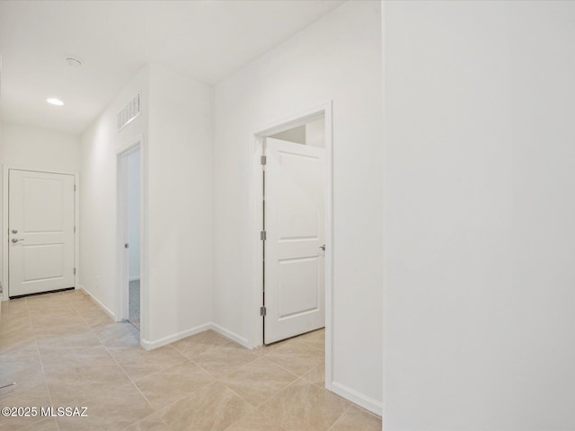 corridor with baseboards, recessed lighting, light tile patterned flooring, and visible vents