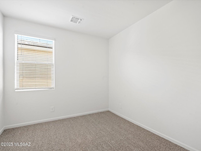 carpeted spare room with baseboards and visible vents