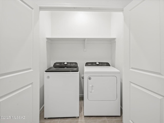 laundry area with laundry area, washing machine and dryer, and light tile patterned floors