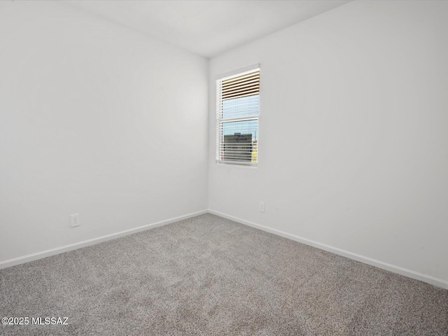 unfurnished room featuring carpet floors and baseboards