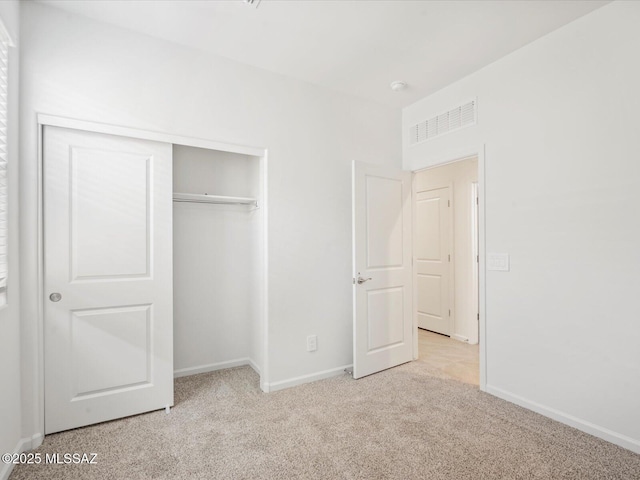 unfurnished bedroom featuring a closet, baseboards, carpet flooring, and visible vents