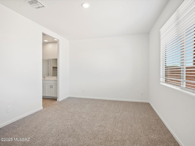 empty room featuring baseboards, light carpet, recessed lighting, and visible vents