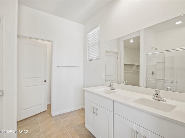 full bathroom featuring double vanity, tile patterned flooring, a sink, and a shower with shower door