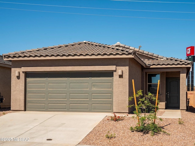 view of front of house with a garage, stucco siding, driveway, and a tile roof