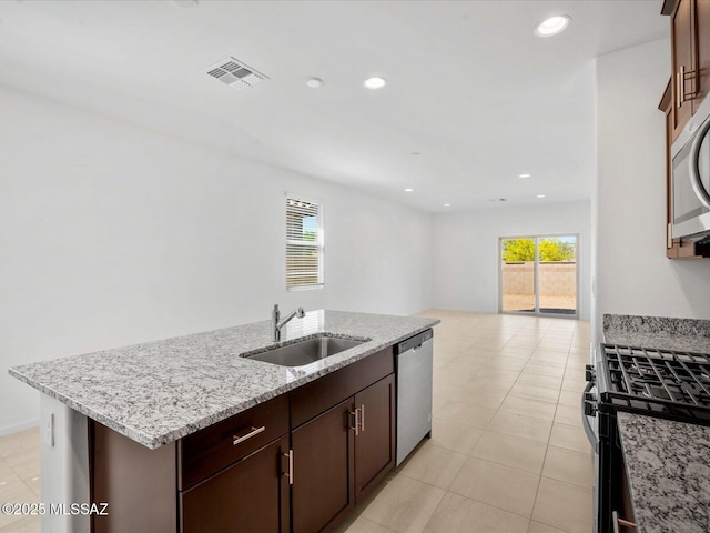kitchen with a sink, an island with sink, plenty of natural light, stainless steel appliances, and visible vents