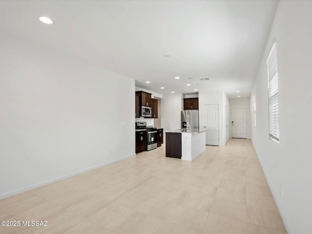 kitchen featuring stainless steel appliances, open floor plan, recessed lighting, and dark brown cabinets