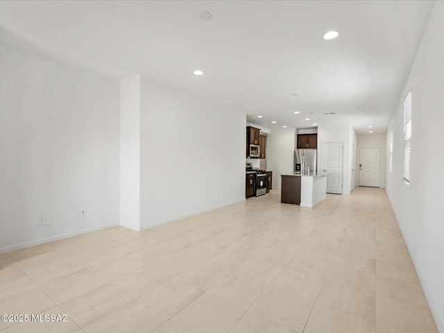 unfurnished living room featuring recessed lighting and baseboards