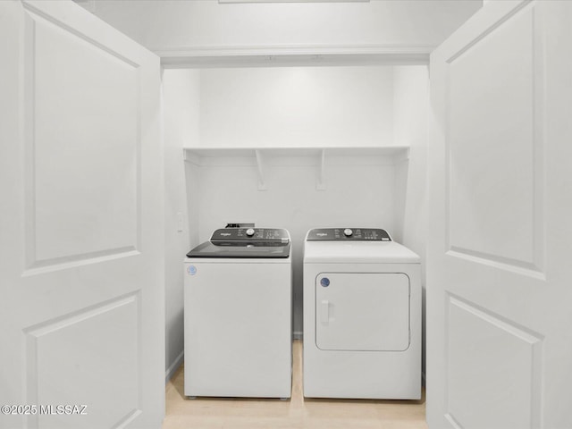 laundry area featuring independent washer and dryer, laundry area, and light wood finished floors