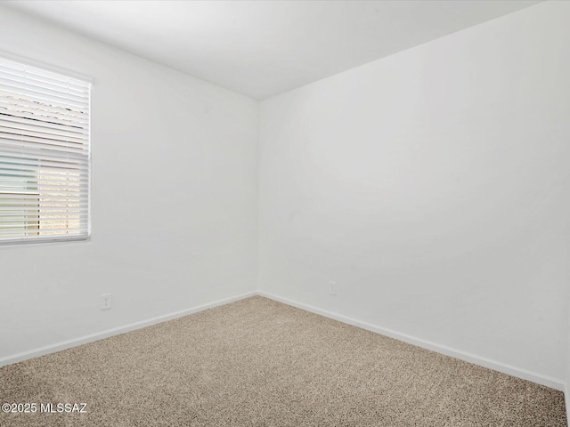 carpeted empty room with baseboards