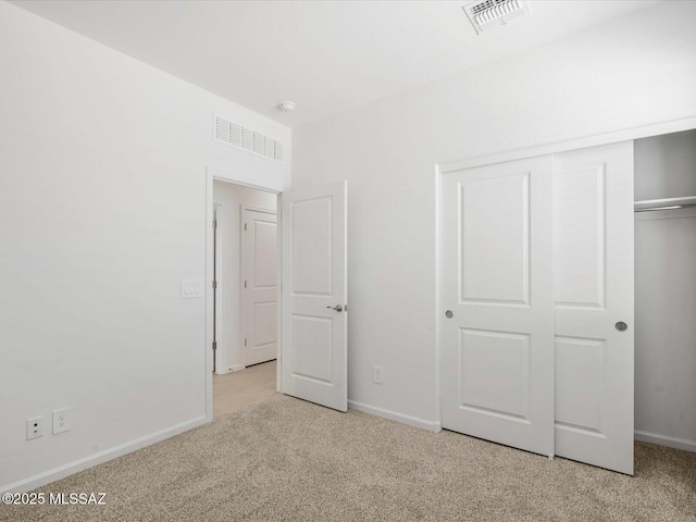 unfurnished bedroom with visible vents, carpet, baseboards, and a closet