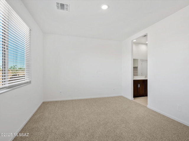 unfurnished room with recessed lighting, baseboards, light colored carpet, and visible vents