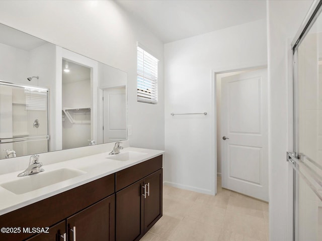 bathroom with double vanity, baseboards, a shower stall, and a sink
