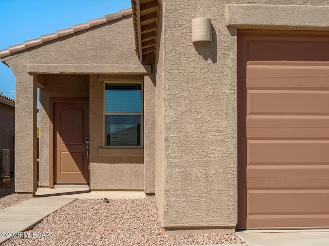 doorway to property with central air condition unit and stucco siding