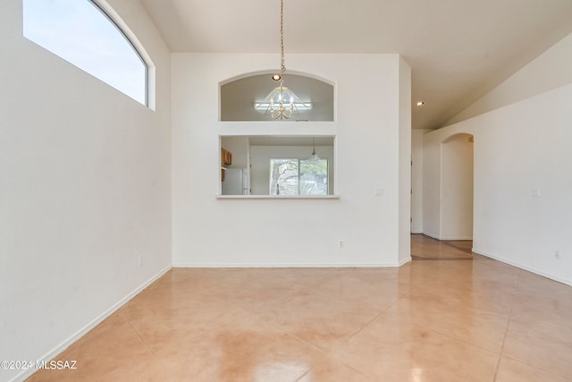 tiled empty room with an inviting chandelier and a towering ceiling