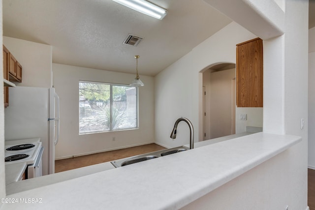 kitchen featuring pendant lighting, white electric range, a textured ceiling, kitchen peninsula, and sink