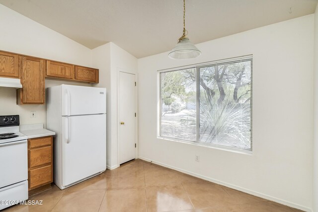 kitchen with lofted ceiling, white appliances, light tile patterned floors, and pendant lighting