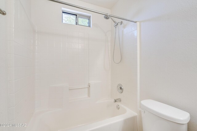 bathroom featuring tiled shower / bath and toilet