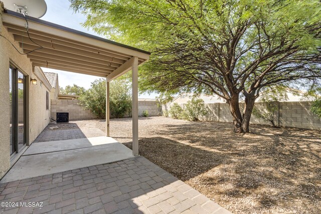 view of yard with central AC and a patio