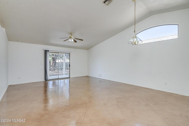 tiled spare room featuring ceiling fan with notable chandelier, a textured ceiling, and vaulted ceiling