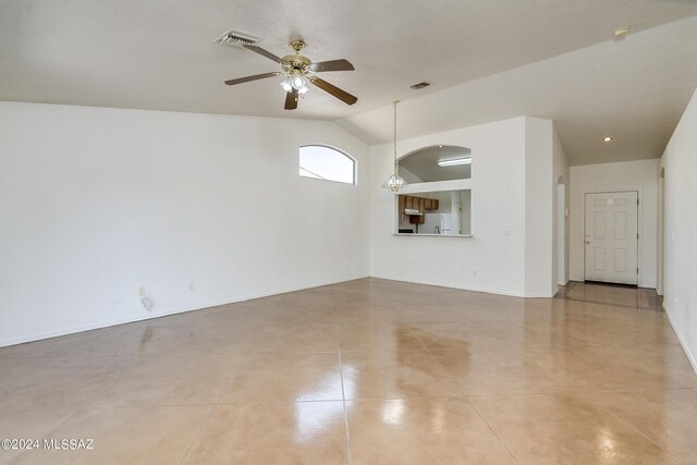 unfurnished living room with lofted ceiling, ceiling fan, and light tile patterned floors