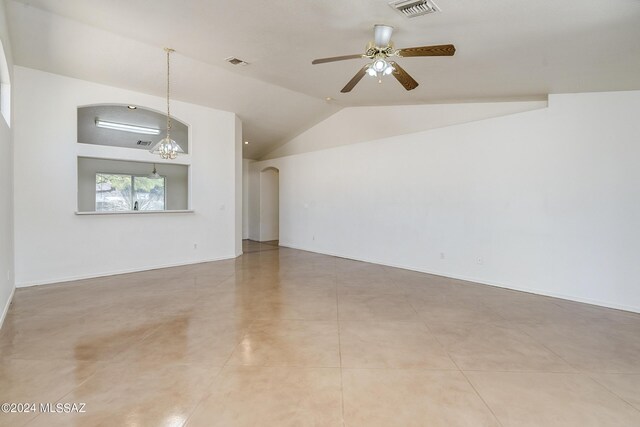 unfurnished living room with ceiling fan, light tile patterned floors, and vaulted ceiling