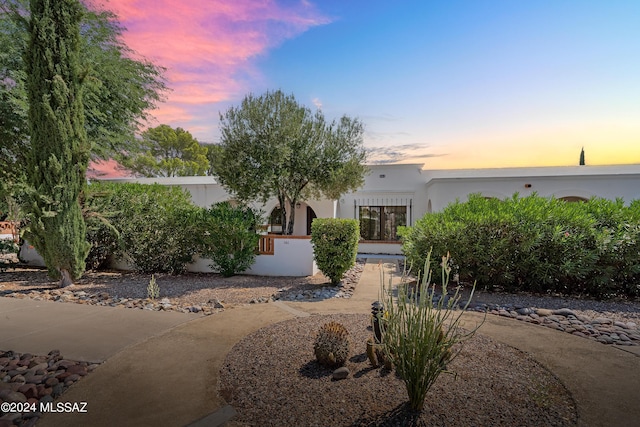 view of front of house featuring stucco siding and a fenced front yard