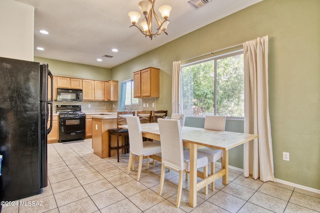 kitchen featuring light brown cabinetry, light tile patterned floors, black appliances, and tasteful backsplash